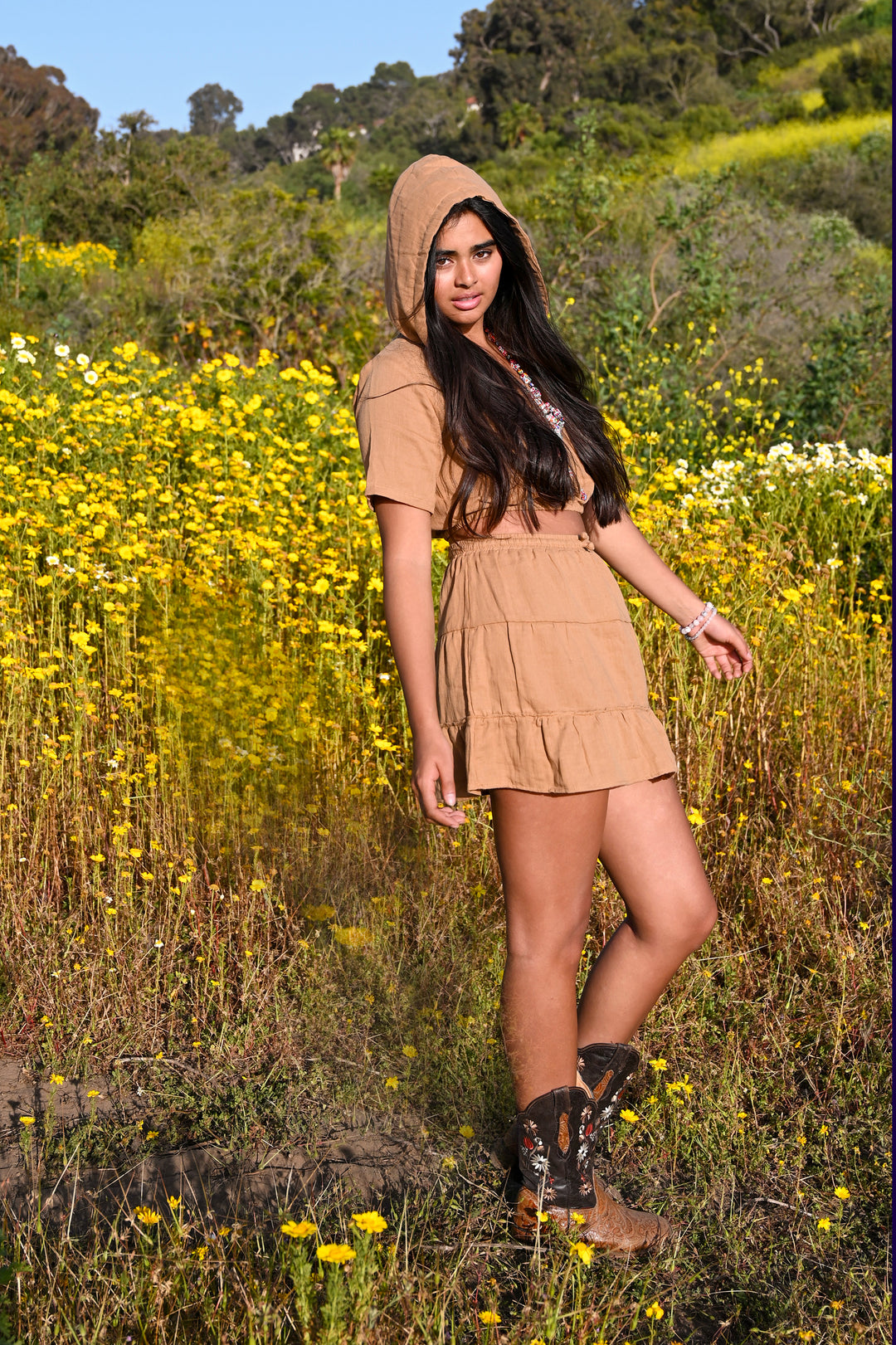 Model wears cropped hoodie and ruffled mini skirt.