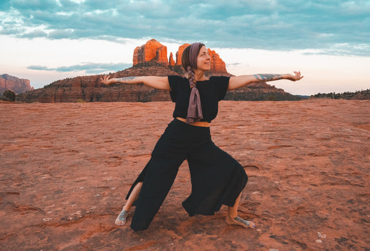 Woman poses in two piece black cotton yoga outfit.