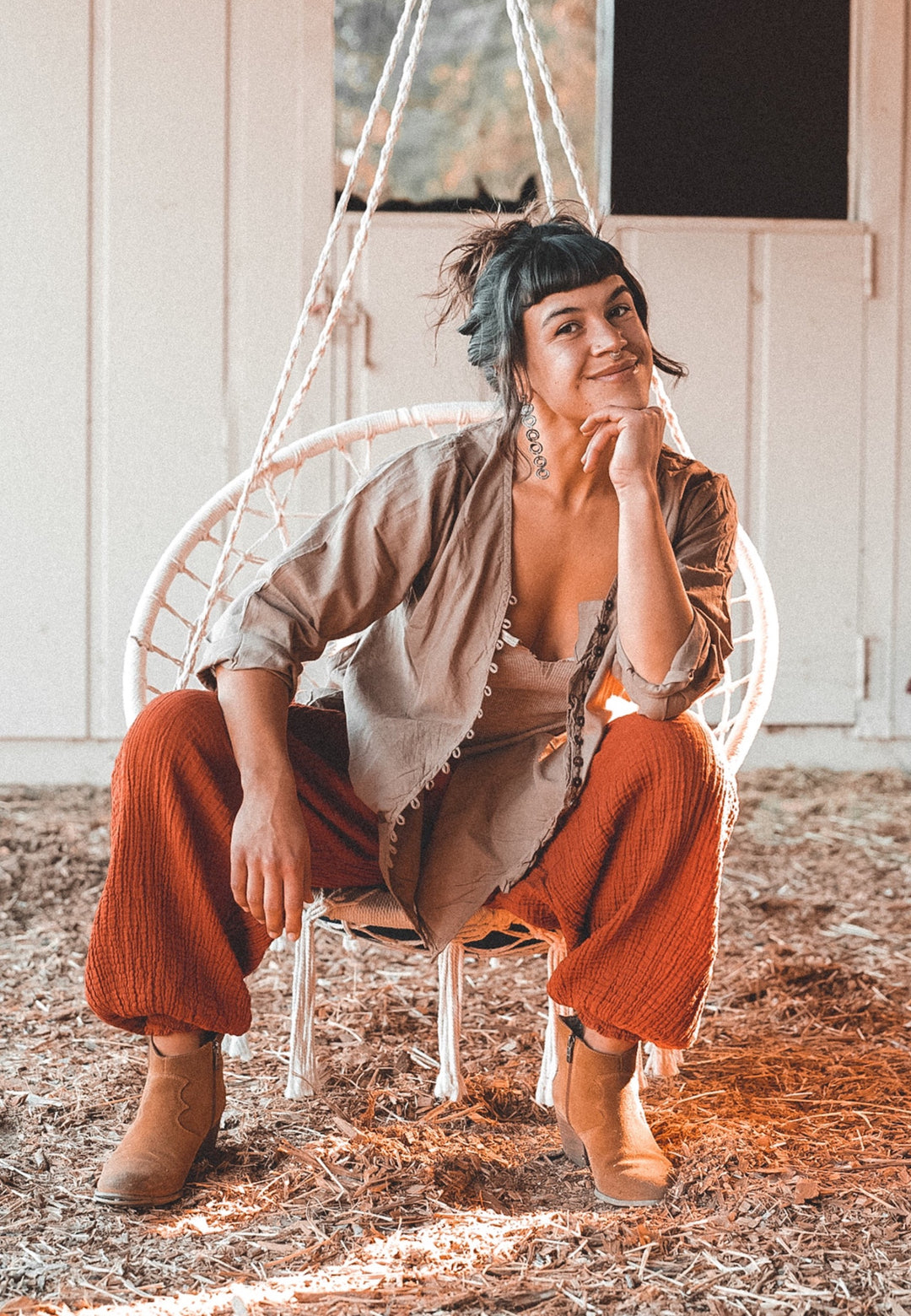 Woman wearing gauze clothing sitting on swing