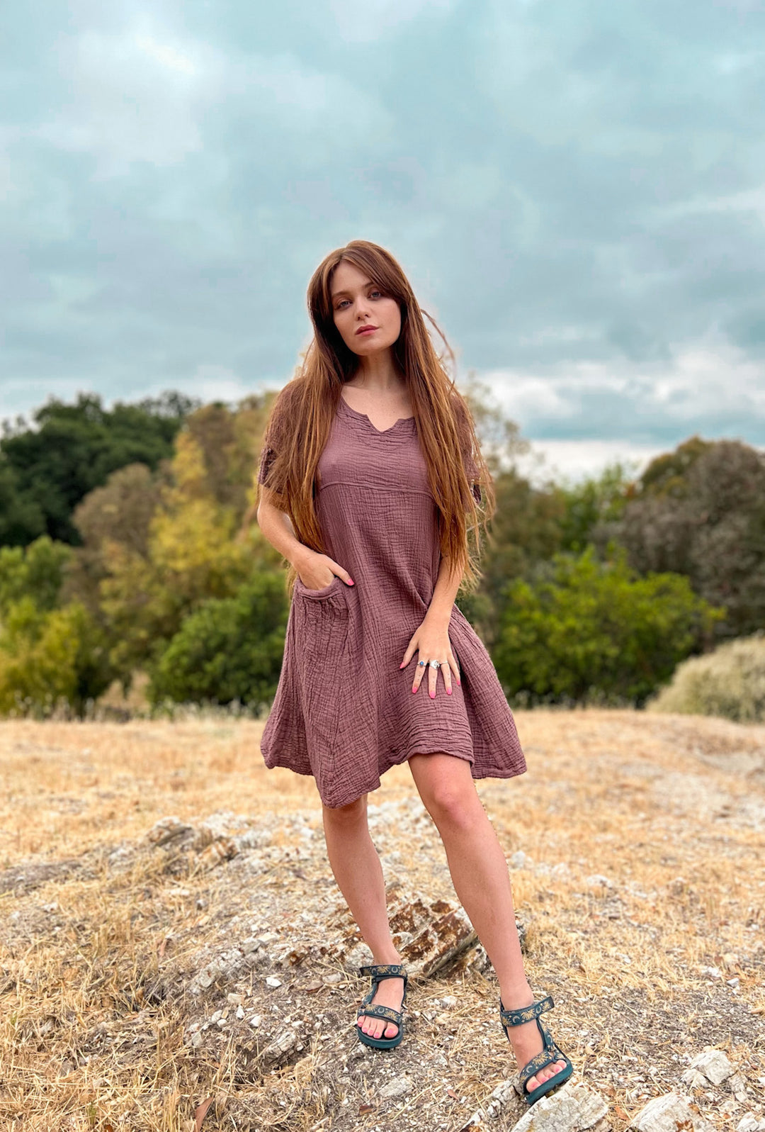 Female model shows off tunic as a dress with pockets.