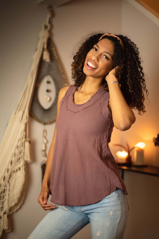 Model is dressed in long purple top paired with jeans.