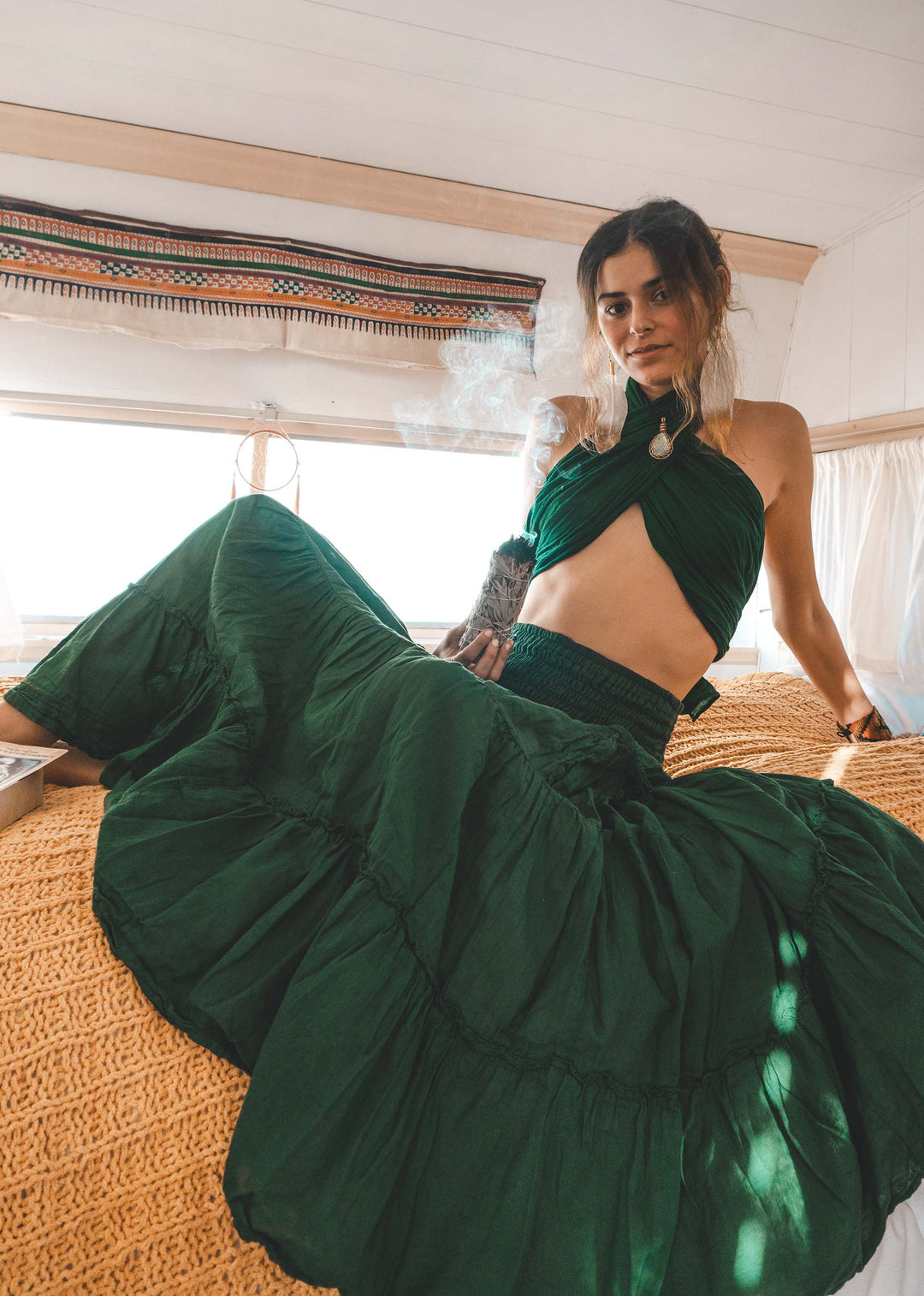 Woman wears green bikini halter top paired iwht full green skirt. 