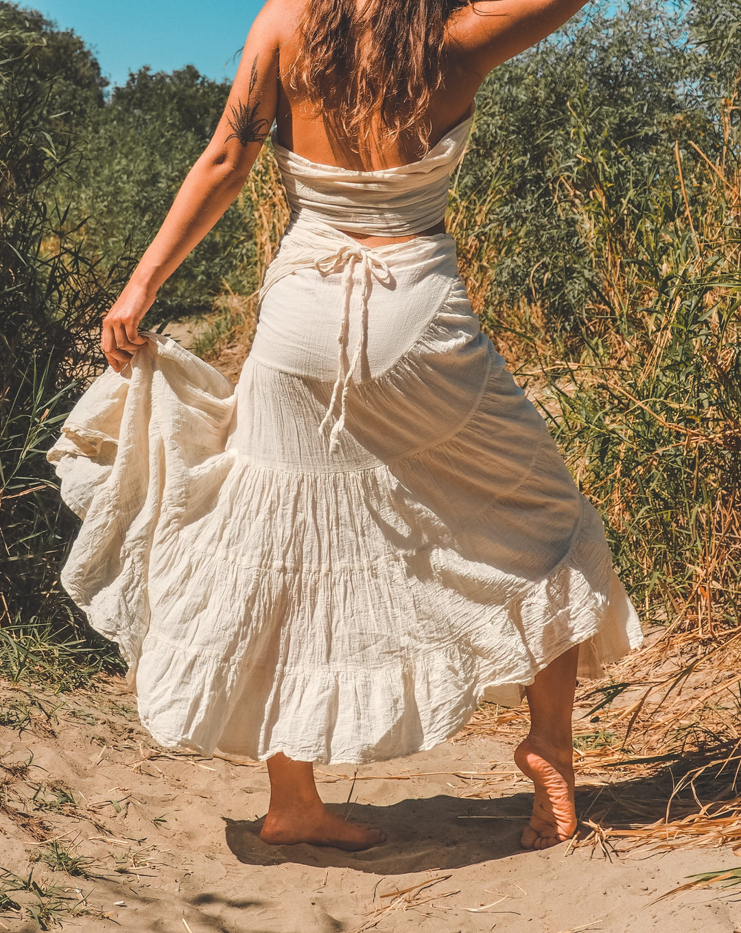 oman in sand wearing und-dyed gauze cotton skirt
