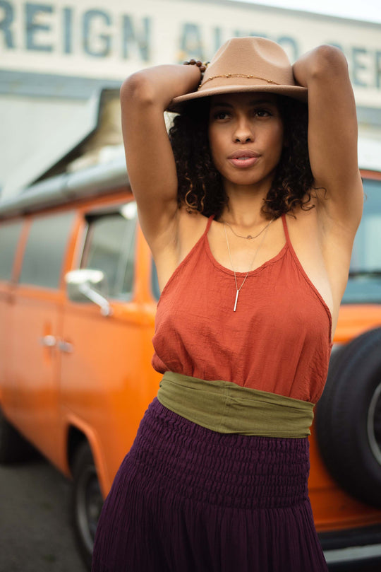 Model is clothed in racerback cami, belt and skirt.