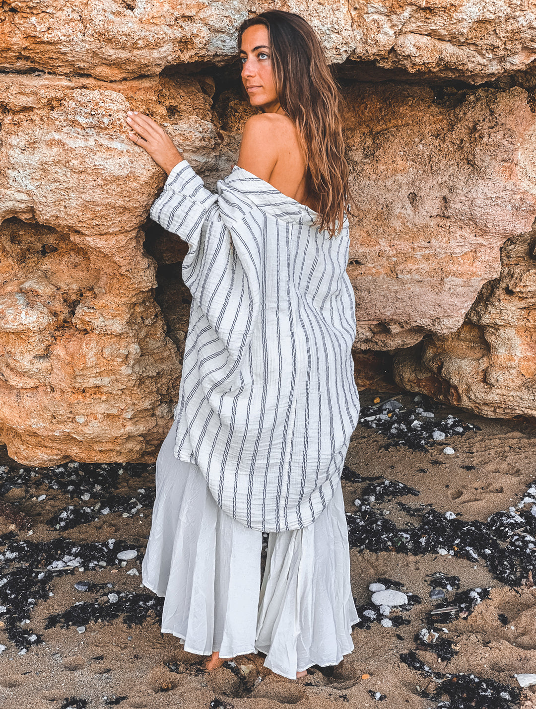 Model poses in long striped wrap and pants.