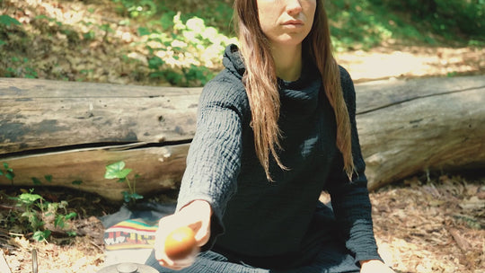 Female model is cozy in a long black gauze cowl neck shirt. 